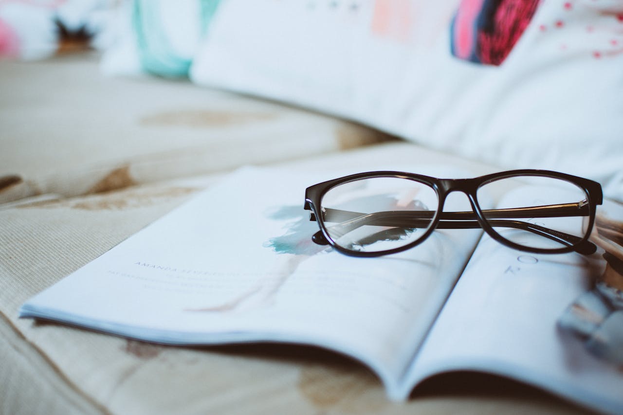 A pair of eyeglasses placed on an open magazine, inviting reading moments.
